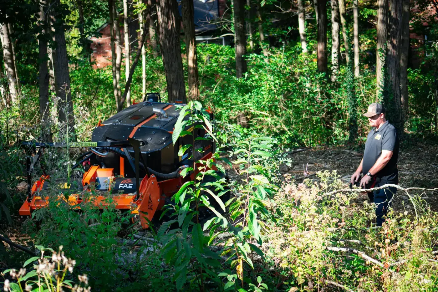 Brushworks operator running a remote forestry mulcher through brush in the woods
